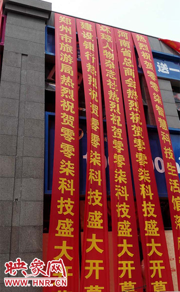 路邊一棟樓上懸掛著二三十條紅色條幅，全部是祝賀一家公司開業(yè)的。