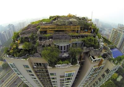　　昨日，身穿橘黃色馬甲的工作人員在人濟(jì)山莊樓頂拆除違章建筑。新京報(bào)記者 吳江 攝