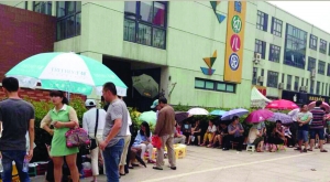 金壇市實(shí)驗(yàn)幼兒園門前，家長(zhǎng)在排隊(duì)