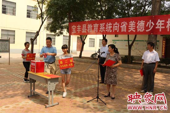 寶豐縣教育系統(tǒng)全體人員在石橋鎮(zhèn)中學為“美德少年”楊冠明同學捐款。