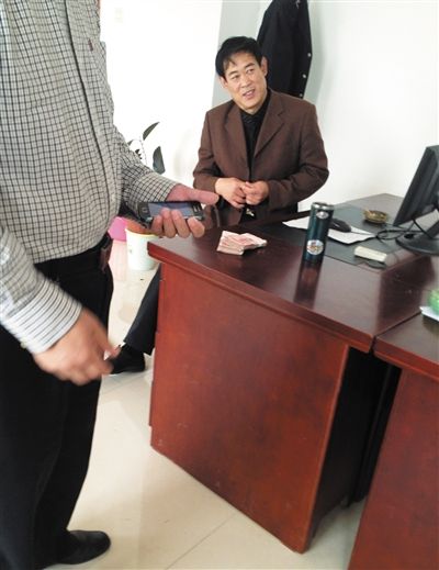 10月29日，獻(xiàn)縣國稅局稽查局辦公室內(nèi)，一名企業(yè)主交了兩萬元現(xiàn)金在桌上。新京報(bào)記者 孟祥超 攝