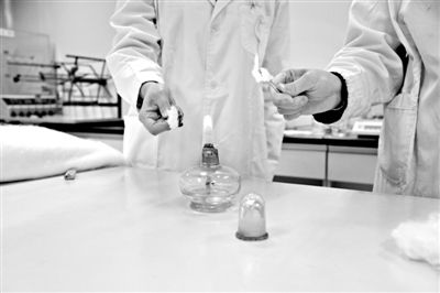 實驗人員操作的燃燒檢測法中，真蠶絲離開火焰就熄滅(左)。