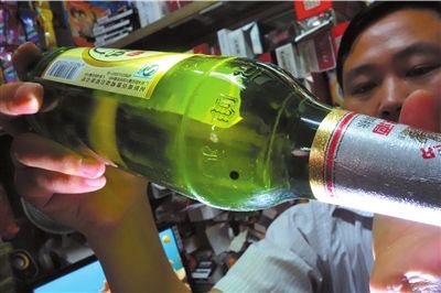 這瓶未開封的燕京啤酒內(nèi)有一顆黑色懸浮物。京華時(shí)報(bào)記者 徐曉帆 攝