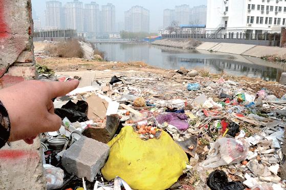 金水河長(zhǎng)江路橋下河水發(fā)臭，水邊堆放眾多垃圾