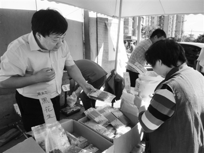 昨日，河南企業(yè)家劉春喜在京“練攤”，為顧客挑選綠豆。新京報(bào)記者 張玉學(xué) 攝