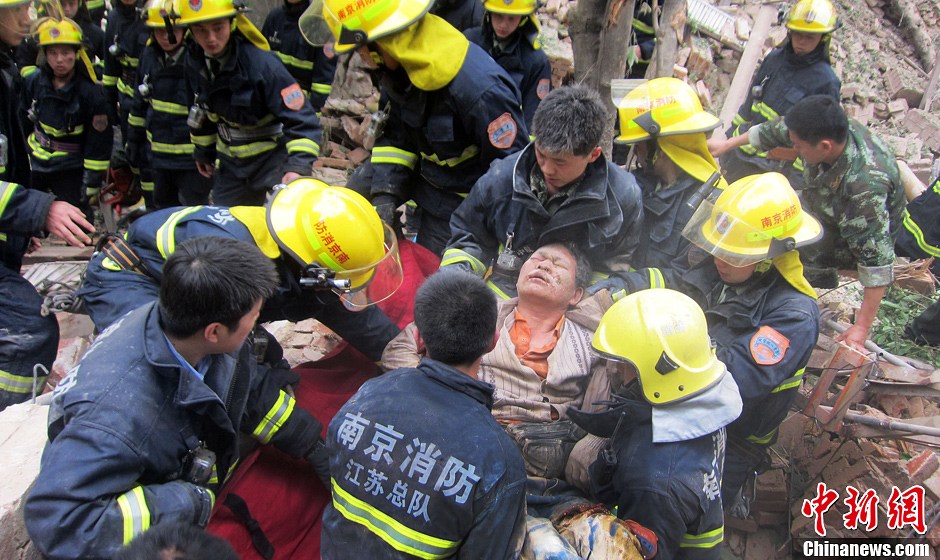 圖為南京消防隊員從廢墟中將傷者抬出。中新社發(fā) 梅亮 攝