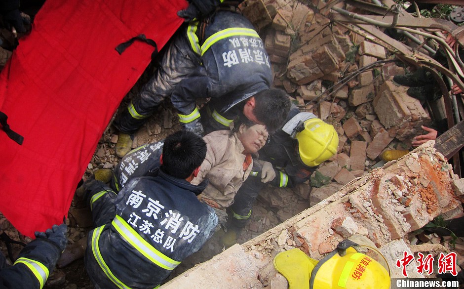 圖為南京消防隊員從廢墟中將傷者抬出。中新社發(fā) 梅亮 攝