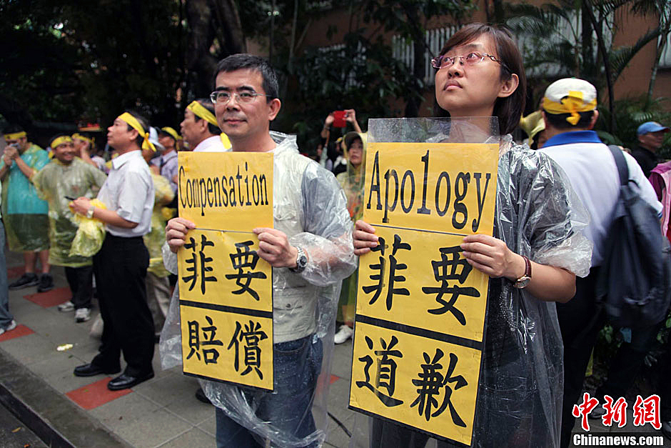 　圖為當(dāng)天下午，當(dāng)臺(tái)灣數(shù)百漁民在馬尼拉經(jīng)濟(jì)文化辦事處前抗議時(shí)，有兩名年輕人手持標(biāo)語，在路邊聲援。中新