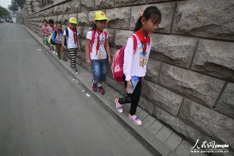2013年09月11日，濟南運署街上，小學(xué)生走史上“最窄人行道”上學(xué)。圖片來源：CFP