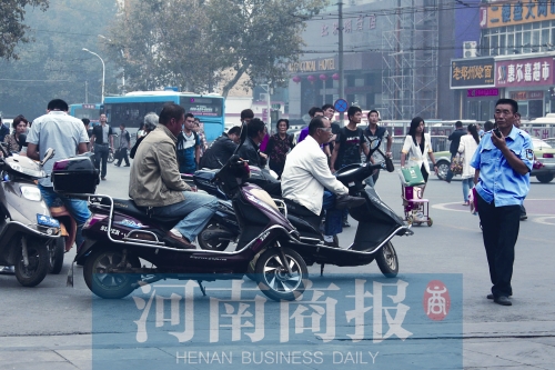　火車站廣場北側(cè)，幾輛摩的正在等客