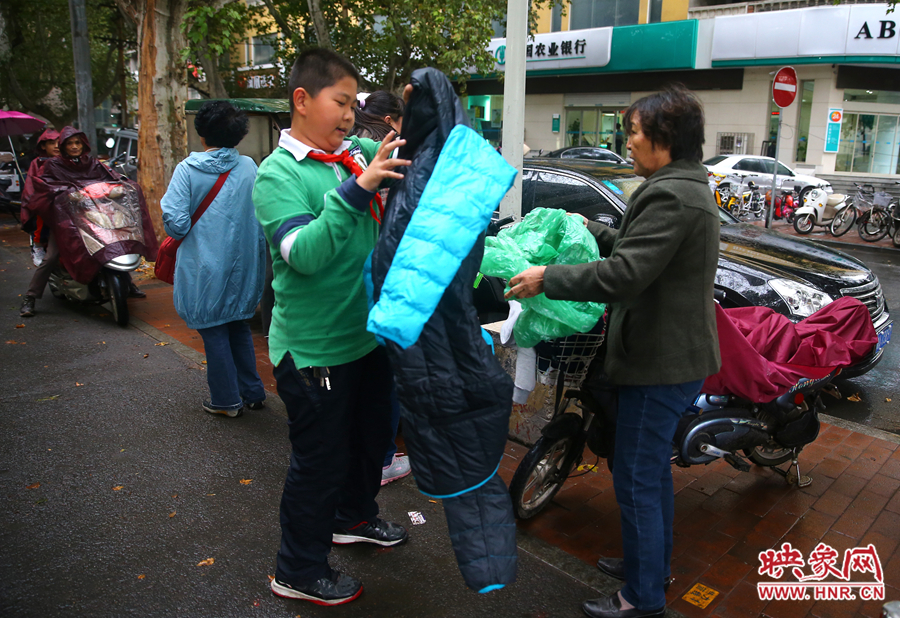 學(xué)校門口，家長給孩子帶來了御寒的厚衣服。