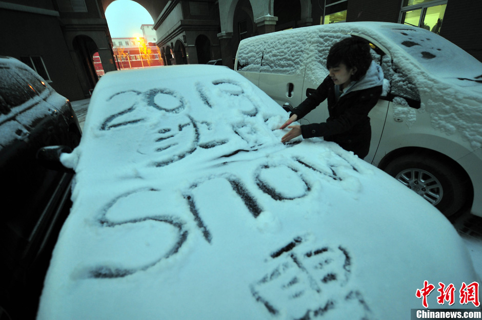11月18日，行人在車輛的積雪上涂鴉。
