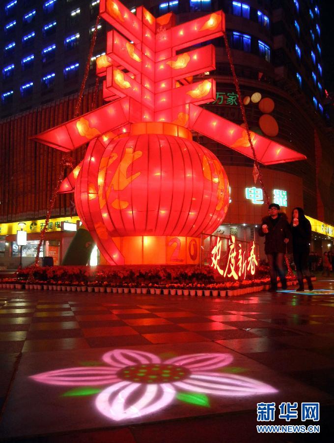 　1月30日晚，市民從蘇州市石路銀河廣場上大型“春”字彩燈景觀旁經(jīng)過。