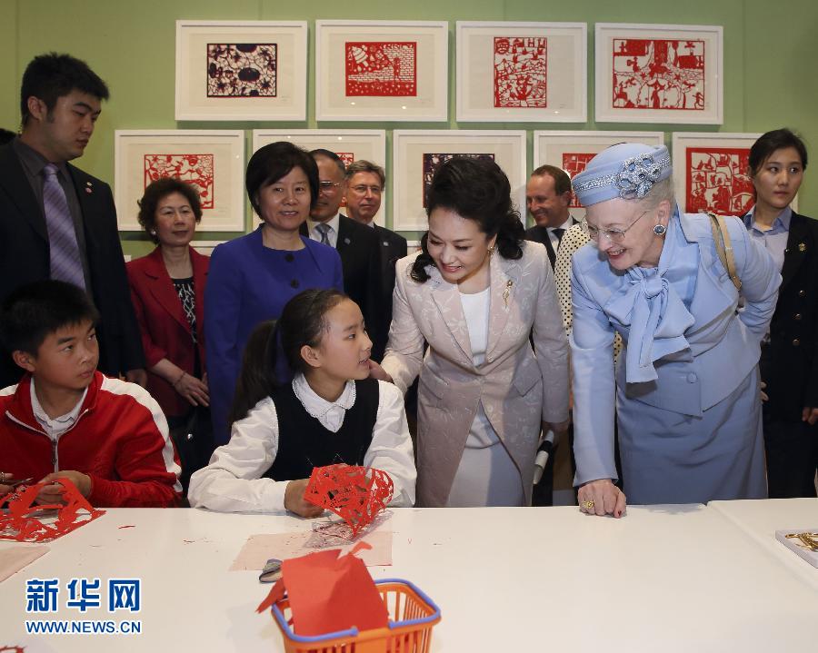 這是彭麗媛和瑪格麗特二世與根據(jù)安徒生童話(huà)中人物和情節(jié)制作剪紙的孩子交談。