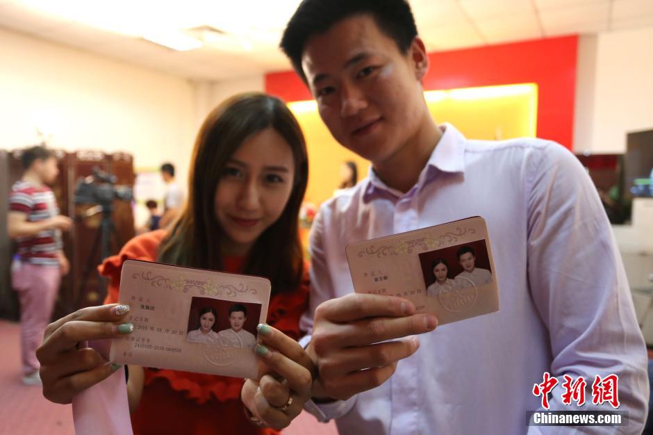 5月20日,河南鄭州,一對(duì)準(zhǔn)新人領(lǐng)完結(jié)婚證后秀自拍。