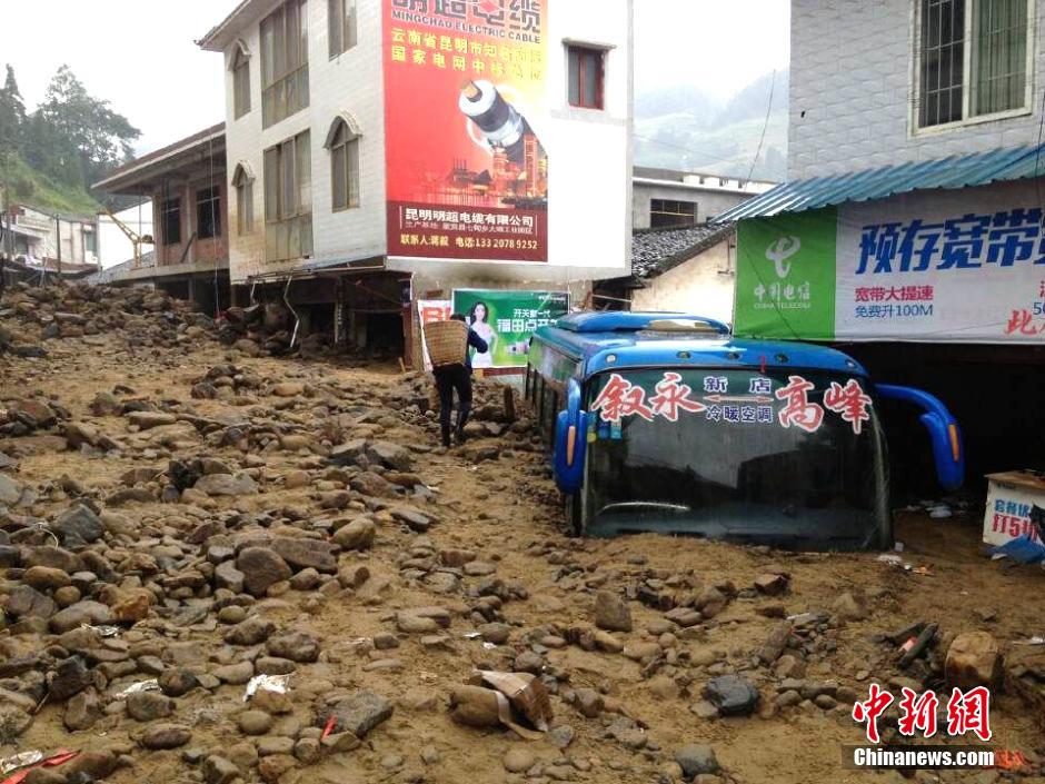 圖為山洪泥石流導沖進鄉(xiāng)鎮(zhèn)街道，導致客車被埋。