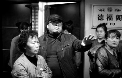 昨日，在河北香河天下第一城，相關負責人（左二）走出會議室與參加演出的老人們溝通。