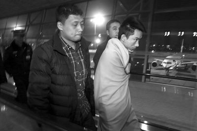 昨日，首都機(jī)場，跨國綁架勒索團(tuán)伙首犯中國籍男子奚某被押解回國。新京報(bào)記者 尹亞飛 攝