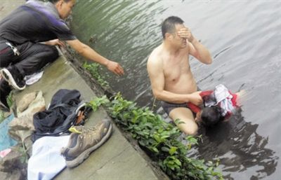 網(wǎng)友貼出民警張光聰一出河水就睜不開眼，用手抹去臉上臟水的照片。