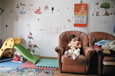 6月14日，未婚媽媽于軍的家里。女兒悅悅抱著兔子玩偶，在聽媽媽手機上的兒歌，這個4歲女孩喜歡兔子。