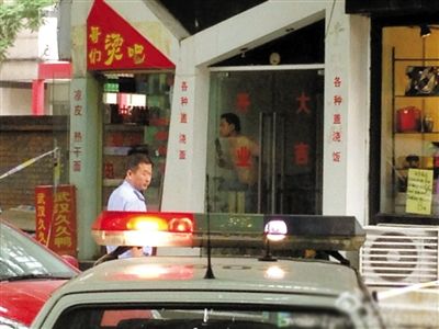 闖入面館的持刀男子與趕來的民警隔著玻璃門對(duì)峙，后店內(nèi)一名女童被其劫持。網(wǎng)友供圖