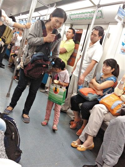 6月27日，舒馨帶一女孩在地鐵十號線行乞。她因被疑帶多個不同小孩乞討被警方搜尋。新京報記者 申志民 攝