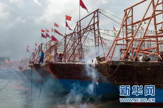 2013年8月1日 南海開漁日 臨高迎新港 8月1日，海南省臨高縣漁民在船上鳴放鞭炮慶祝武蓮港開港。