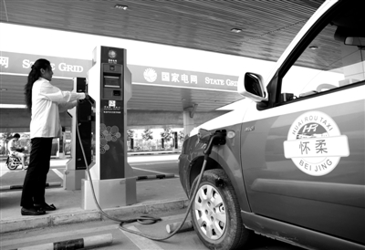 9月11日，懷柔區(qū)，電動(dòng)出租車司機(jī)正在為車輛充電。