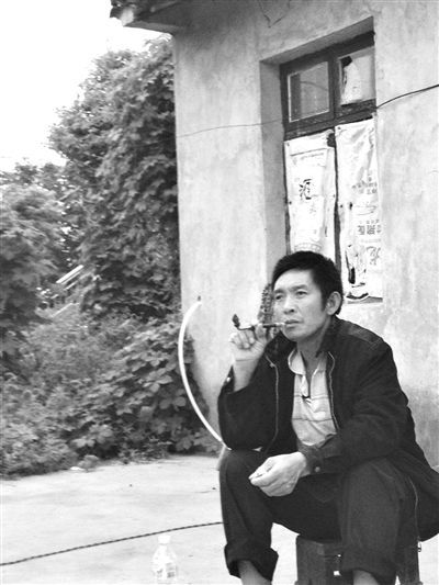 9月12日，陳文才在自己的出租屋旁抽煙。新京報(bào)記者 朱柳笛 攝