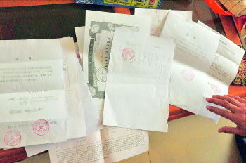 60歲的市民仇先生為了辦理公證所需的這些證明材料,半個月時間里跑了30多趟腿。記者　李萌博　攝