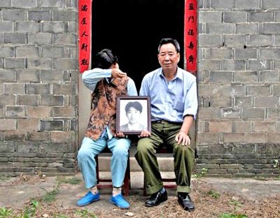 江蘇鎮(zhèn)江，老劉夫婦捧著獨生子的遺像在老家前留影南方都市報供圖L