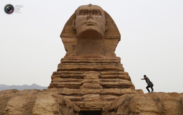 石家莊郊外，一名男子與山寨版獅身人面像合影留念。