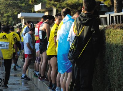 2013年10月20日，北京馬拉松比賽，由于廁位有限，一些選手在綠化帶“就地解決”。圖/IC