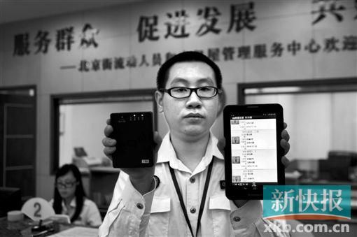 　越秀區(qū)北京街出租屋外來(lái)暫住人員管理服務(wù)中心的工作人員展示到出租屋登記來(lái)穗人員信息的儀器。