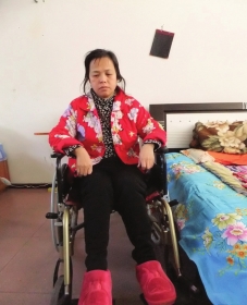 陳慶霞坐在輪椅上。她現(xiàn)在下身癱瘓，疾病纏身，生活不能自理。