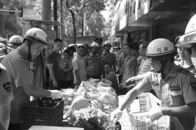 7月11日，瀏陽市北正中路，執(zhí)法人員暫扣張海的水果。這是瀏陽市城管局拍攝的執(zhí)法現(xiàn)場(chǎng)圖。