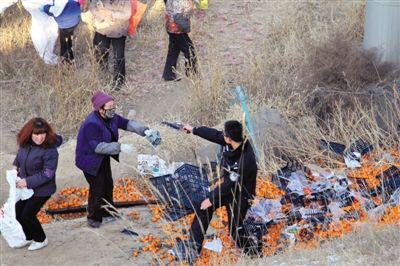 1月4日，連霍高速蘭州市榆中縣和平鎮(zhèn)段，一名警察舉著槍驅(qū)散哄搶橘子的村民。圖/CFP