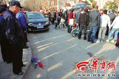 車禍現(xiàn)場的血跡被人用土覆蓋，旁邊則放著紅領(lǐng)巾、一雙童鞋和一頂帽子 本報(bào)記者 趙彬 攝