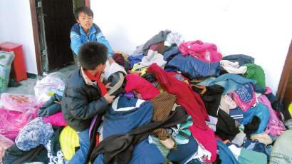 學(xué)生在幫忙整理收到的捐贈(zèng)衣服。得石中心校供圖
