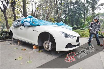 昨日，停放在重慶大學(xué)B區(qū)的一輛瑪莎拉蒂豪車被架在幾塊磚頭上，車輪不翼而飛。 重慶晨報記者 胡杰 攝