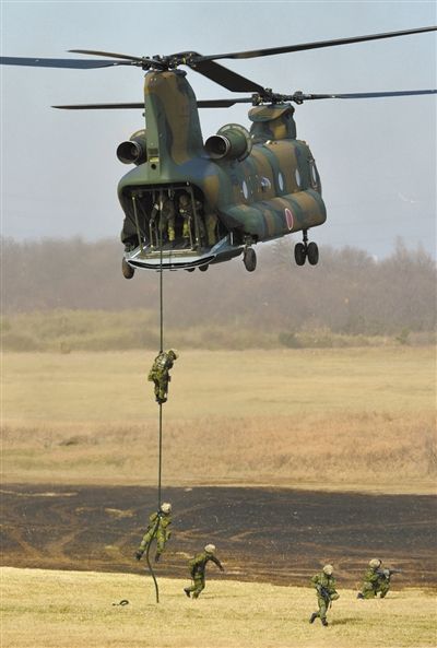 “登島” 1月13日，位于東京的習(xí)志野市，日本自衛(wèi)隊隊員在新年軍演中演練直升機(jī)登島行動。