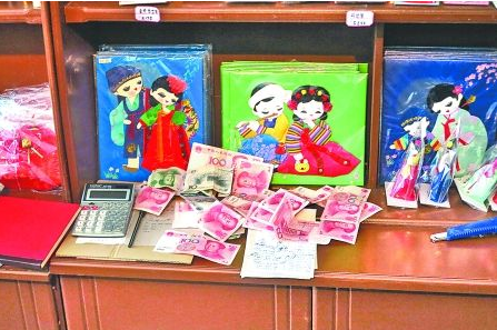 　　2012年6月21日，在朝鮮羅先特別市的一家商店里，柜臺(tái)上散落著一些人民幣。在朝鮮，人民幣比本國(guó)