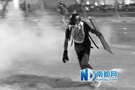 反政府示威者在與警察的沖突中躲避催淚彈。