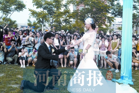 在學校操場的草坪上，兩名畢業(yè)生舉行婚禮，有同學感動地抹起眼淚