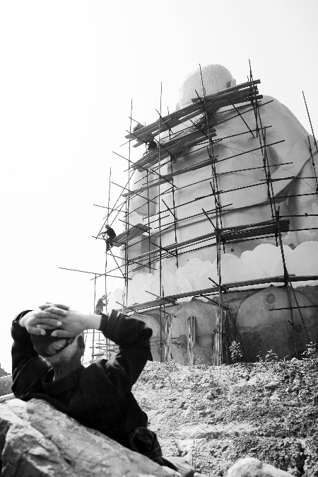 今年4月26日，工作人員將帆布蓋在“佛像”頭像上