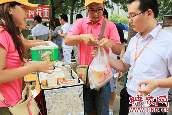 圖為徐貴雨和一名勤工助學(xué)的學(xué)生在街頭義賣(mài)快餐。