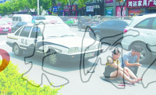 事故發(fā)生后，警車司機(jī)（右）下車查看傷者并撥打120，倆“領(lǐng)導(dǎo)”穩(wěn)坐車內(nèi)引發(fā)圍觀者不滿。