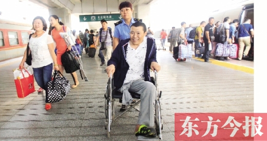 李剛手術(shù)后歸來(lái)，在車站工作人員幫助下走出鄭州火車站站臺(tái)  東方今報(bào)首席記者 張曉冬 攝
