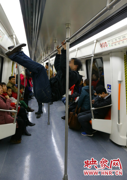 地鐵試乘日，一男子在車廂內(nèi)攀爬扶手自娛自樂