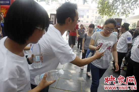志愿者為剛剛考試完的考生送上1瓶冰凍的冰露·純悅，消暑解渴為考生加油